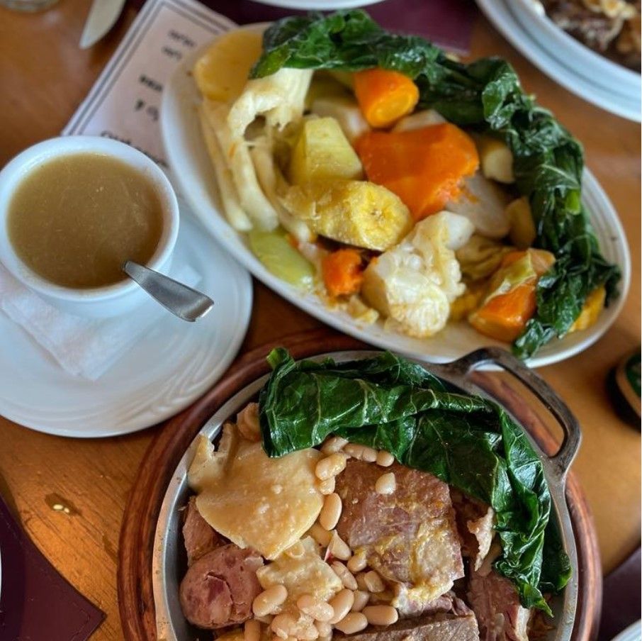 platos de carne y verduras y una taza de caldo con cuchara al lado, coida típica portuguesa - weroad