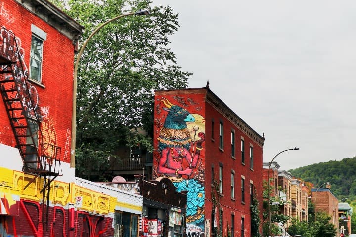 edificios pintados de rojo con murales en una de las más bonitas street art cities, montreal - weroad