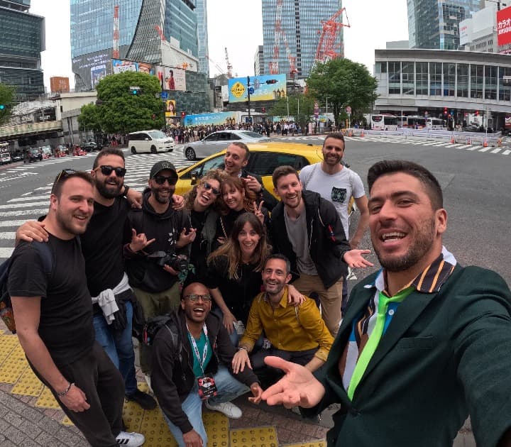 selfie de viajeros weroad en una calle moderna de tokio, edificios y coches detrás