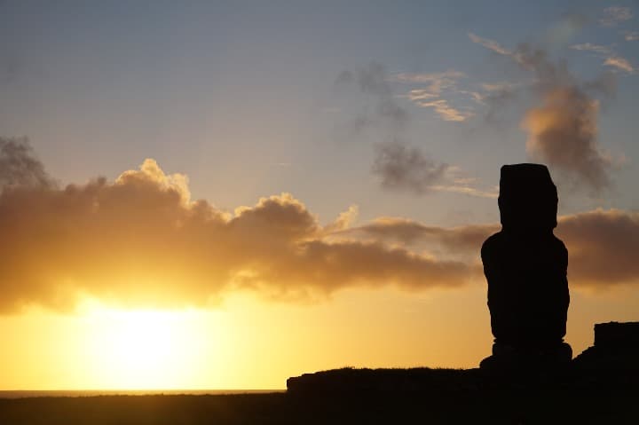 estatua moai a contraluz en la isla de pascua, detrás luz solar al atardecer