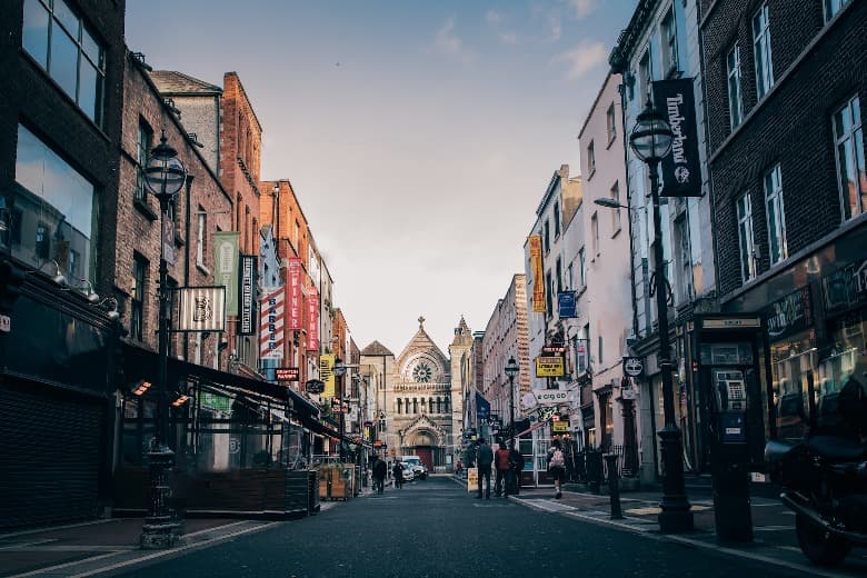 calle con tiendas e iglesia al fondo en dublín, destino que ver en irlanda  - weroad