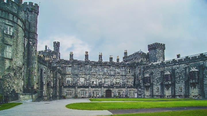 castillo de kilkenny, cesped verde delante de zonas del edificio - weroad