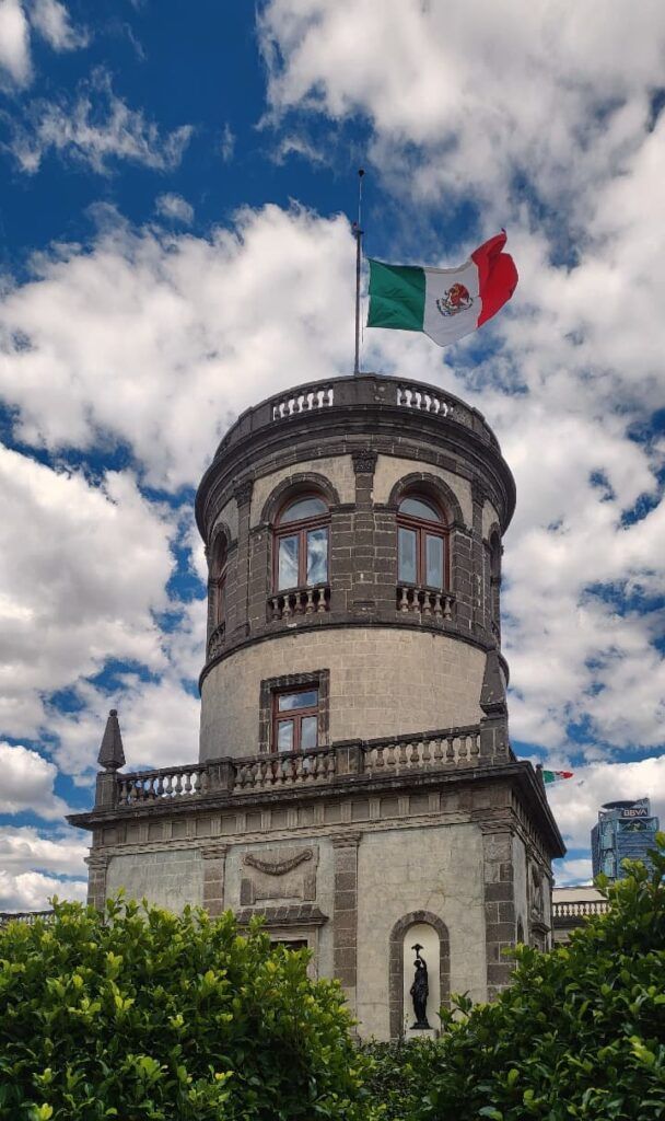 Castillo de Chapultepec con bandera mexicana encima y cielo con nubes dertas