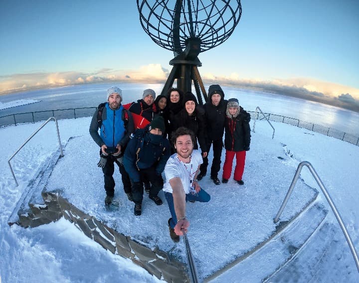 selfie de grupo de viajeros de weroad en cabo norte, paisaje de nieve detrás