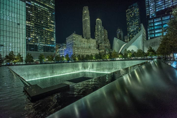 ground zero, rascacielos y fuente iluminados, de noche, en nueva york