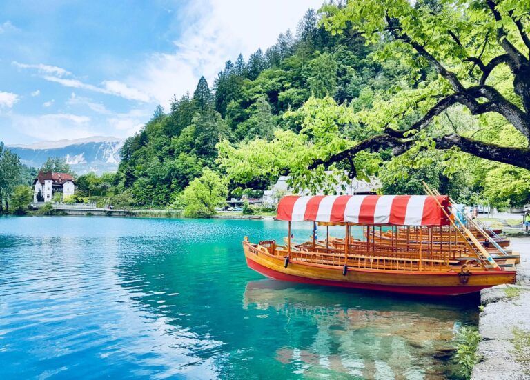lago de bled con barco con techo a rayas blancas y rojas