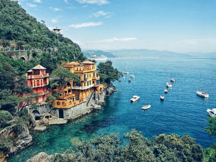 mar con barquitos y casas en portofino, un destino para vacaciones en italia