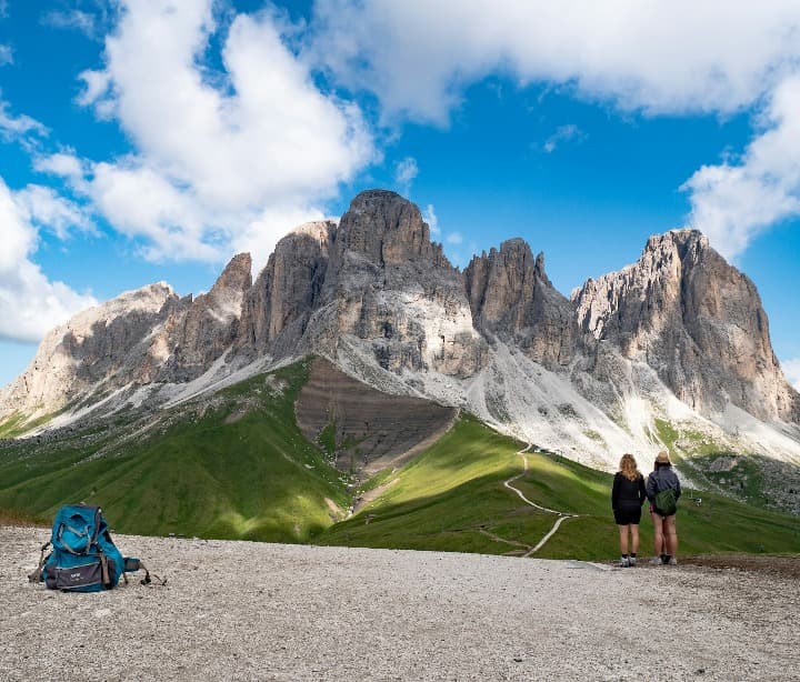dos personas delante de una montaña en Rifugio Des Alpes, Campitello di Fassa, en trentino alto adige, destino para unas vacaciones en italia