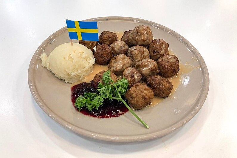 Köttbullar, plato de albondigas con puré y mermelada y bandera sueca