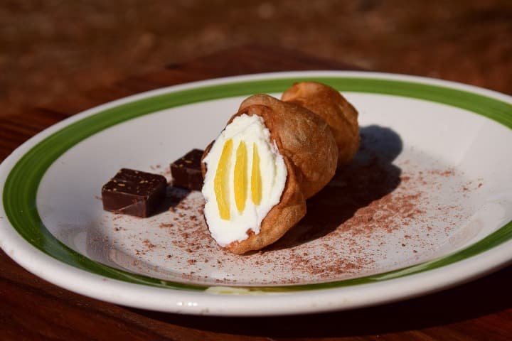 cannolo con un poco de chocolate al lado, comida tipica de sicilia