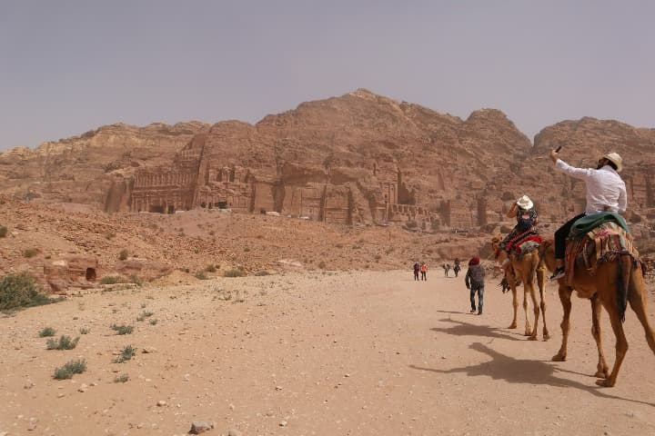 personas en camello dirigiendose hacia petra