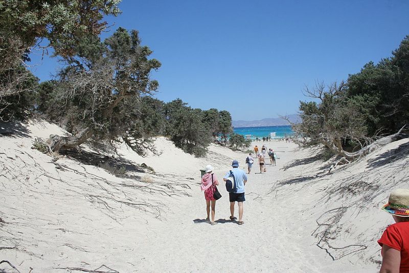 gente caminandoen la arena hacia la playa de chrissi