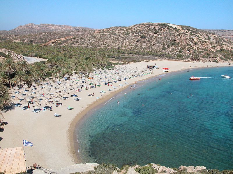 playa de vai becach con tumbonas y gente, montaña al fondo, una de las playas de creta