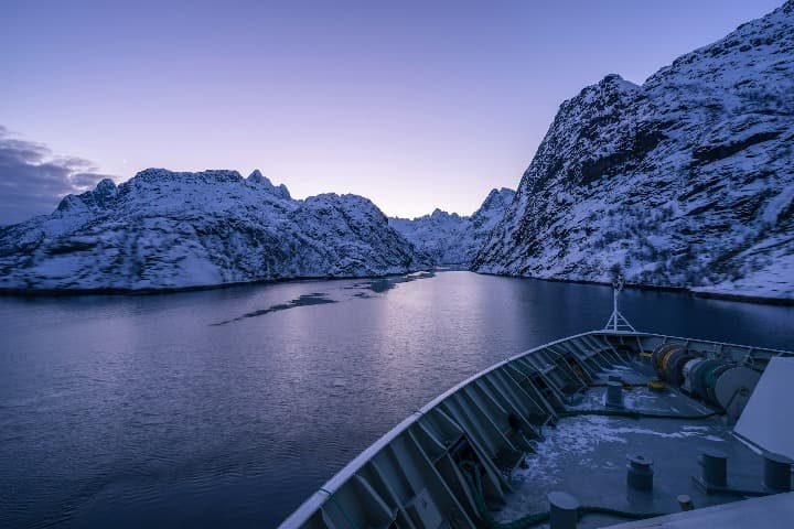 fiordo de Trollfjord visto desde un barco con luz azulada