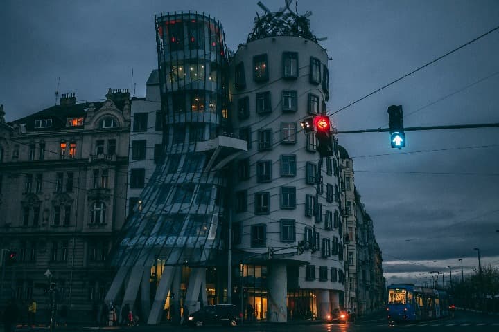 casa danzante con semaforo delante, cielo oscuro y nubes al fondo. algo que ver en praga en 3 días