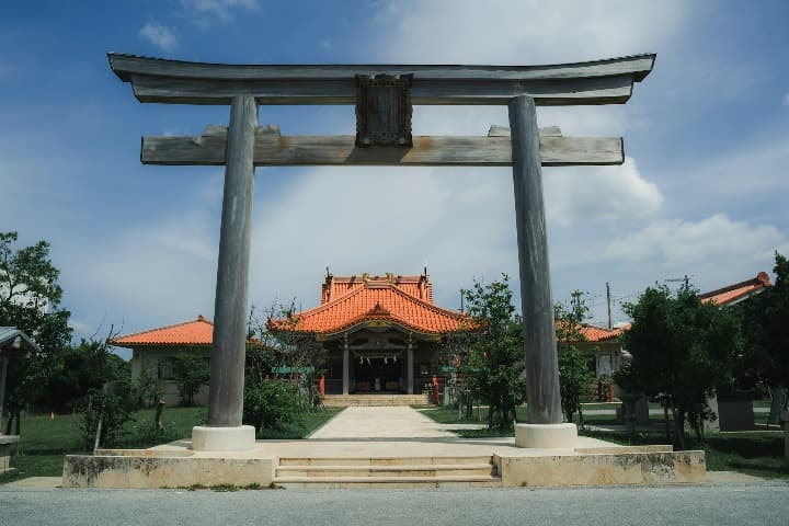 Tori delante de edificio típico japones en Miyakojima, en Owinawa