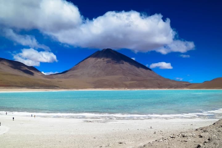 agua azulada delante de una montaña, nubes en el cielo en laguna verde, algo que ver en bolivia