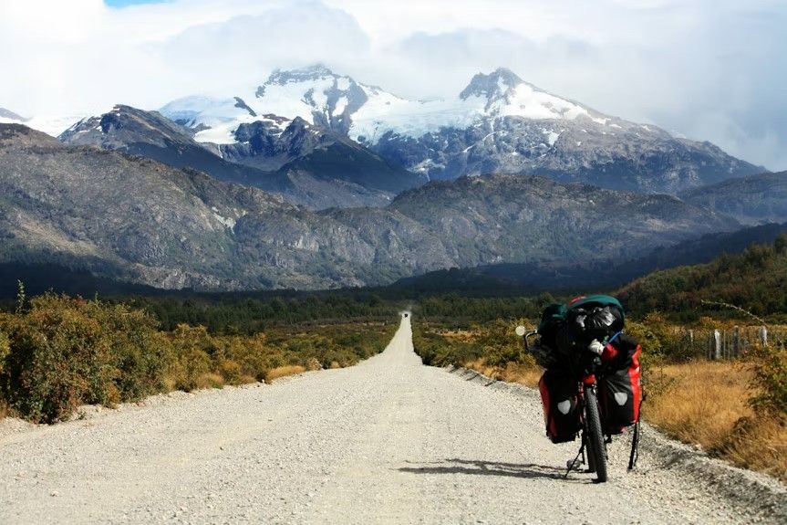 montaña y caretera austral en medio, co moto vista desde detrás en primer plano