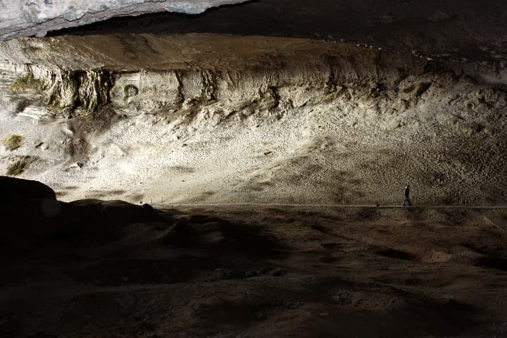 hombre caminando en el interior de la cueva de milodon, paredes de piedra