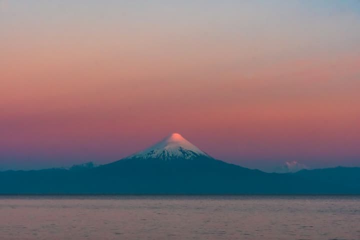 volcan de osrono con punta con nieve, cielo rosado, algo que ver en chile