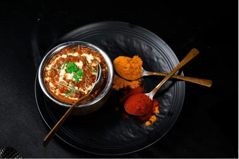 plato de lentejas con cucharitas con especias de colores al lado, daal, comida típica india