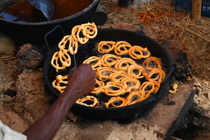 dulces fritos friendo en una olla, jalebi, comida típica india