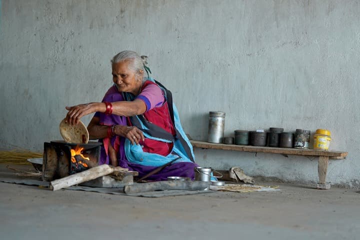 señora india preparando una paratha con un hornillo con furgo vivo