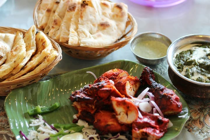 plato de pollo tandoori y pan detrás, comida típica india