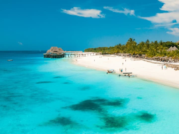 playa con agua azul, palmeras al fondo, mejor época para viajar a zanzíbar