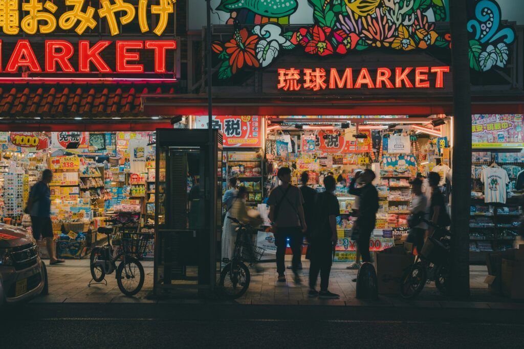 tiendas de snacks y letreros en neon en Kokusai-dori, una de las calles principales de Naha, algo que ver en okinawa