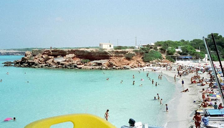 agua azul y gente en la playa de cala saona, formentera