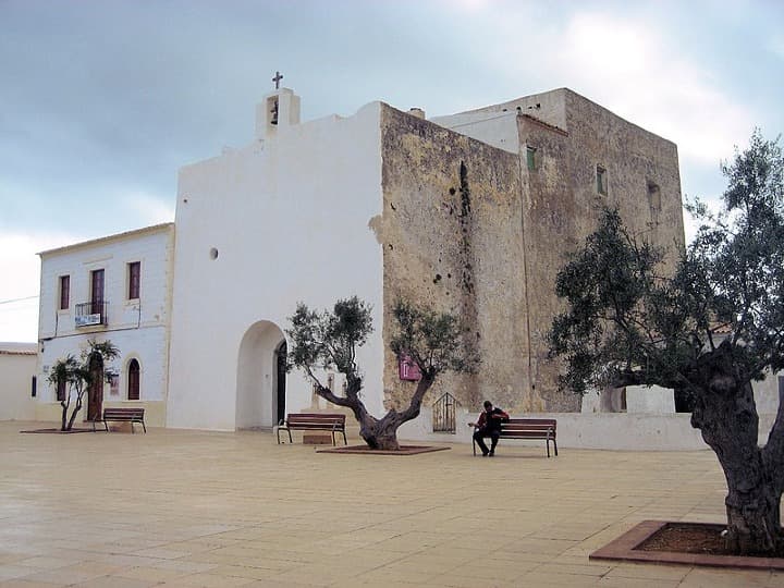 edificio blanco con ulivos delante en una plaza en sant francesc xavier, algo que ver en formentera