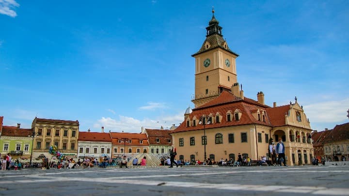 centro del pueblo de brasov, con plaza, edificio con torre., algo que ver en transilvania