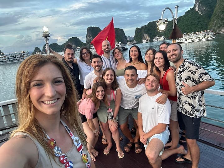 selfie de viajeros weroad en hanoi, montñas y bandera detrás