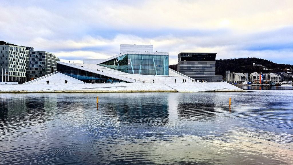 Ópera de Oslo con su arquitectura moderna reflejada en el agua.