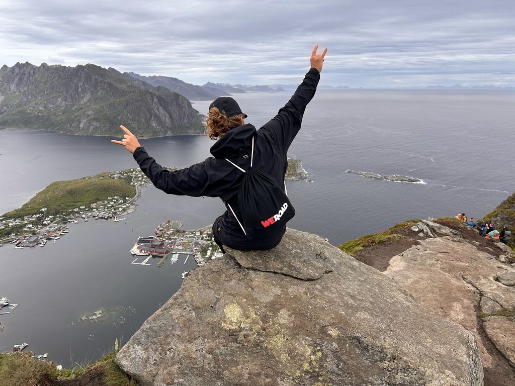 Viajero con mochila WeRoad disfrutando de las vistas desde una cima en Noruega.