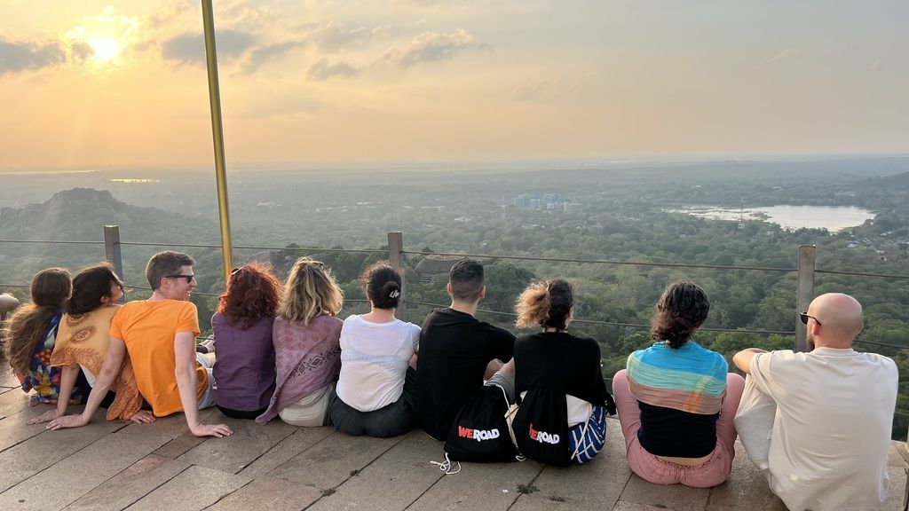 Grupo de viajeros WeRoad disfrutando del atardecer desde un mirador en Sri Lanka.