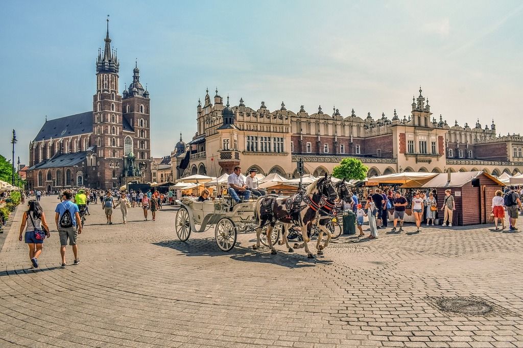 Plaza del Mercado Principal en Cracovia, Polonia, con caballos y carruajes frente a la Basílica de Santa María.