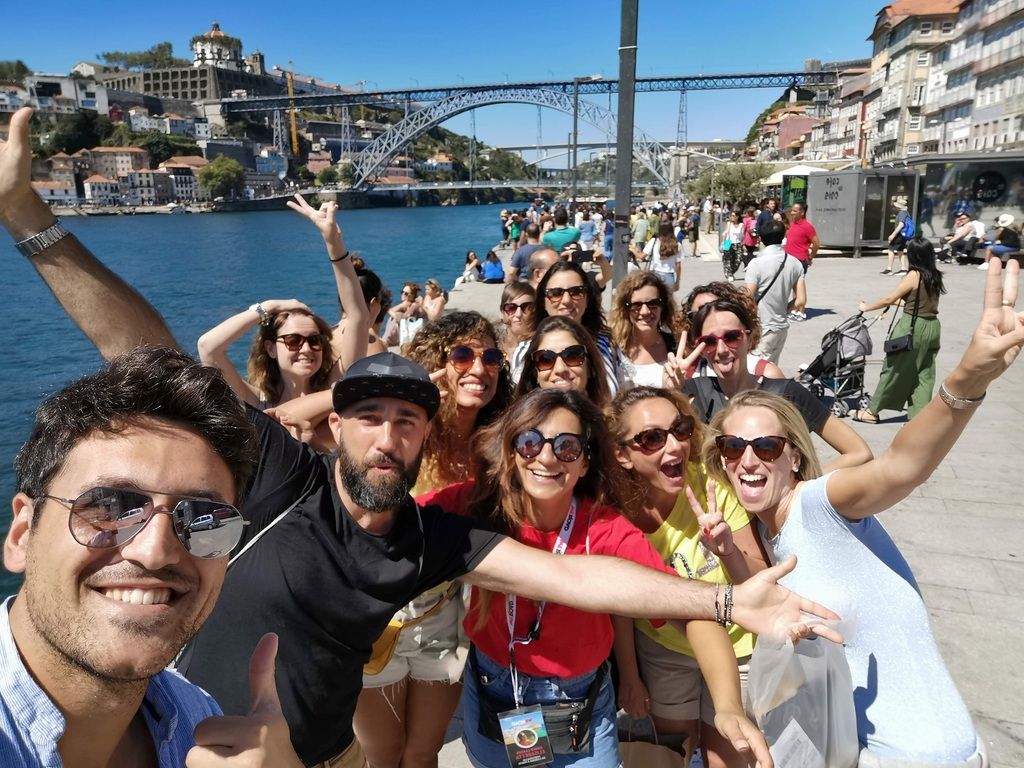 Grupo de viajeros WeRoad disfrutando en la ciudad de Oporto frente al río Duero.