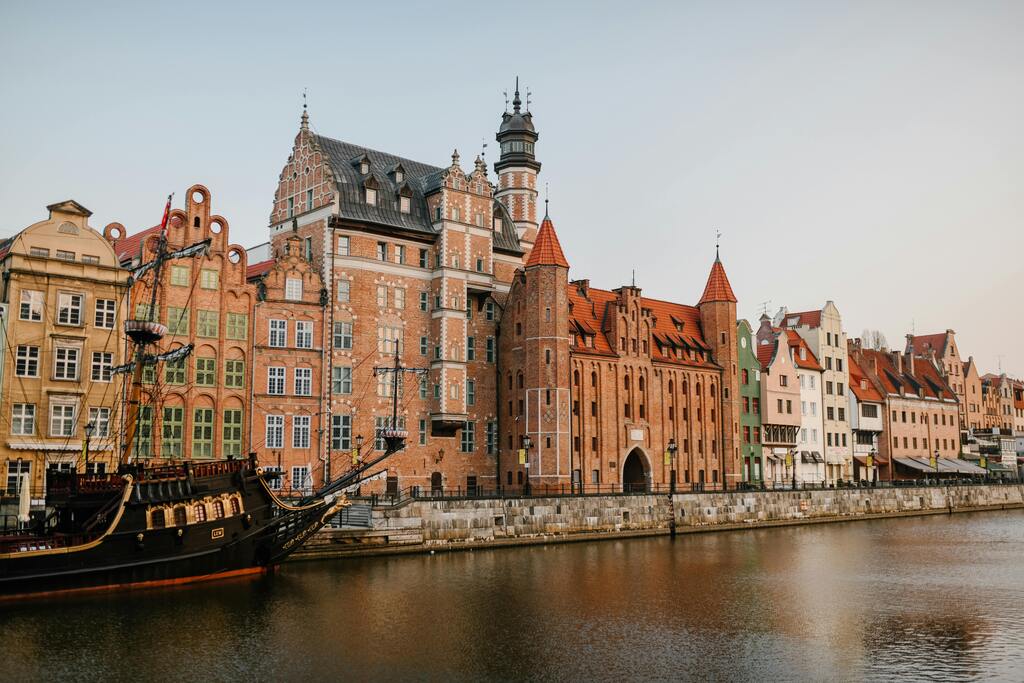 Casas coloridas y un barco histórico en el paseo marítimo de Gdansk, Polonia.