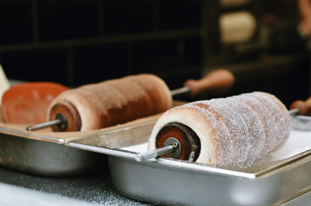 Kürtőskalács, un postre tradicional húngaro en proceso de preparación en un horno.