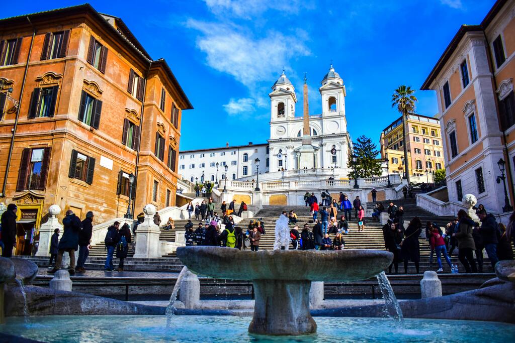 Plaza de España en Roma con su famosa escalinata y turistas disfrutando del ambiente.
