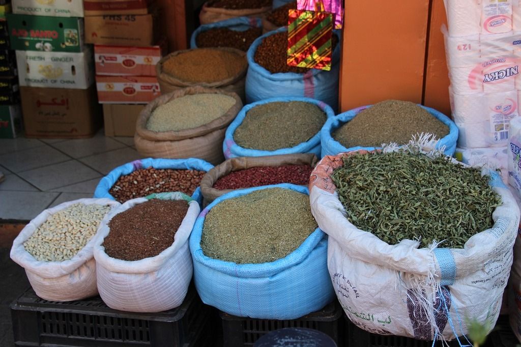 Sacos de especias y granos en un mercado marroquí, mostrando la rica tradición culinaria del país.