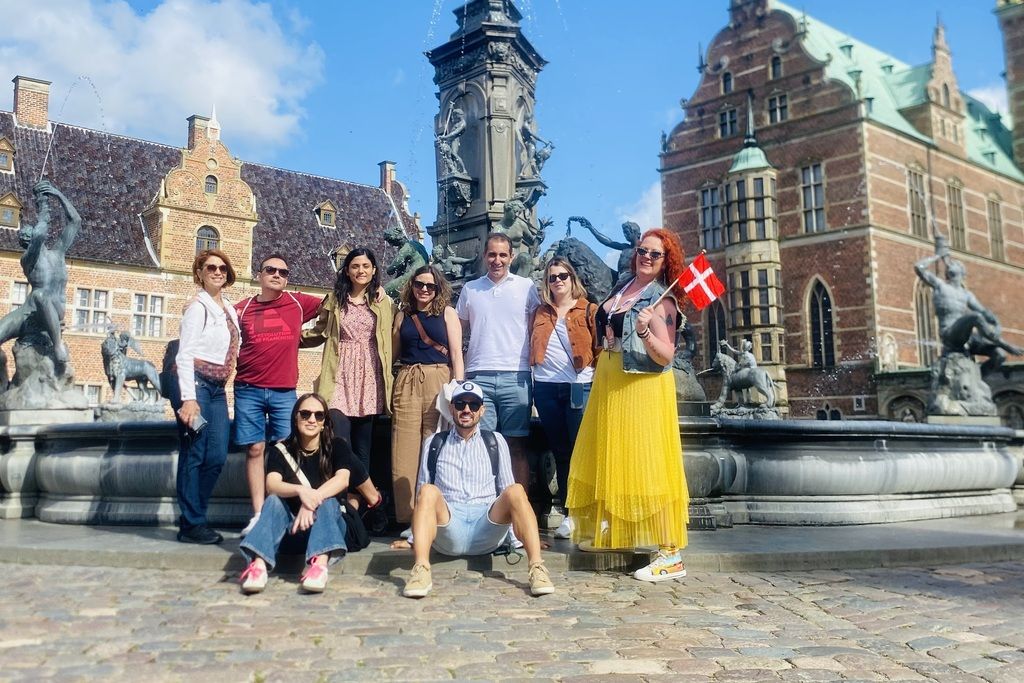 Viaje en grupo organizado por WeRoad a Copenhague, frente a una fuente en un día soleado.