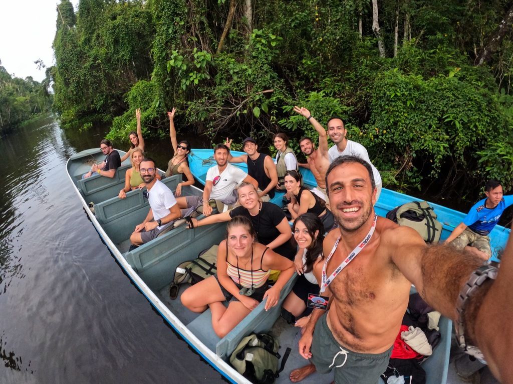 Grupo de viajeros WeRoad explorando un río en la selva de Malasia.