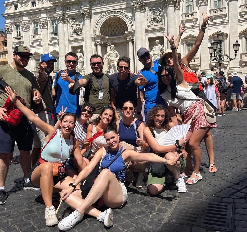 Grupo de viajeros en un tour organizado por WeRoad en Roma, posando frente a la Fontana di Trevi.
