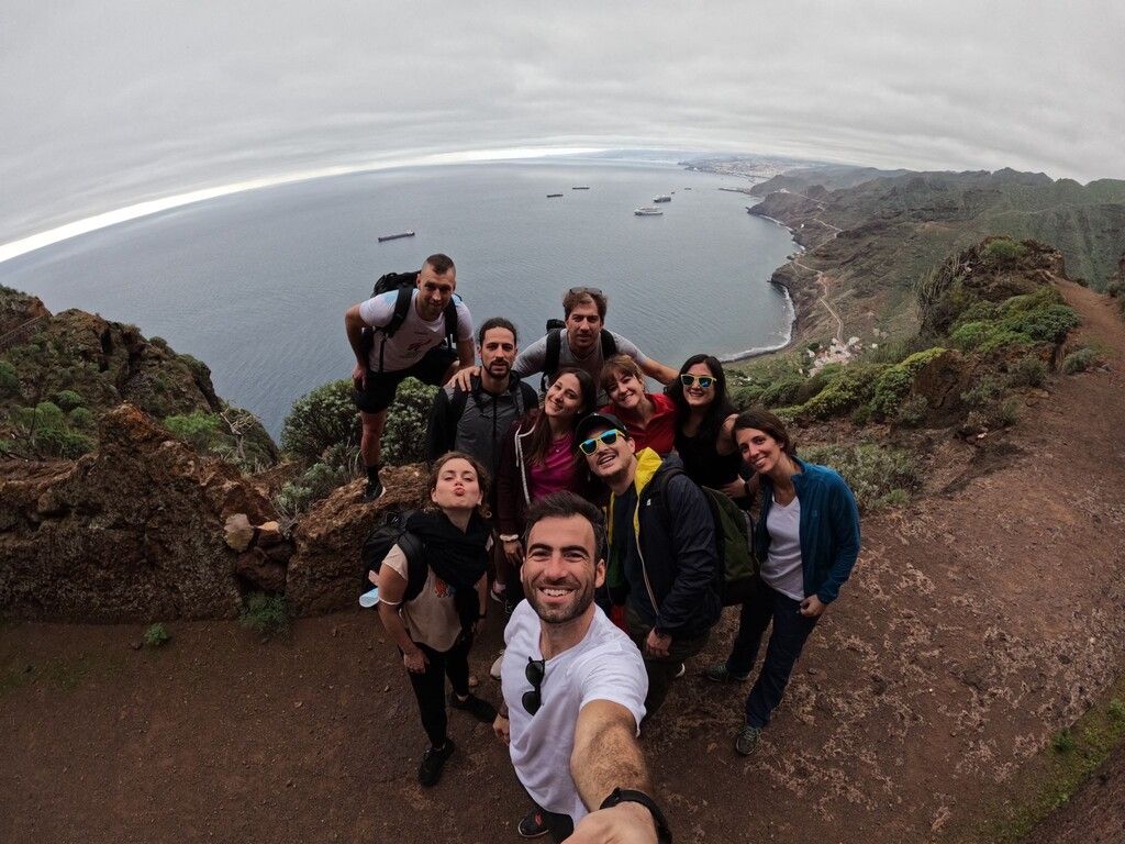 Grupo de viajeros de WeRoad disfrutando de una excursión en Tenerife, con vistas al océano y paisajes naturales impresionantes.