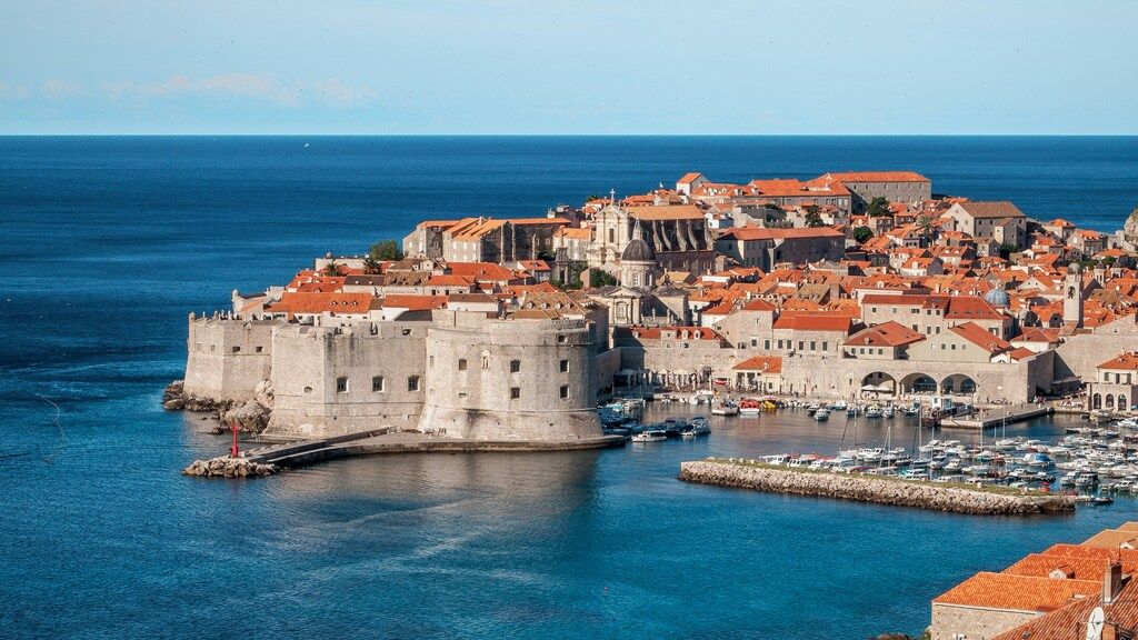 Vista aérea del casco antiguo amurallado de Dubrovnik con tejados naranjas y el mar Adriático