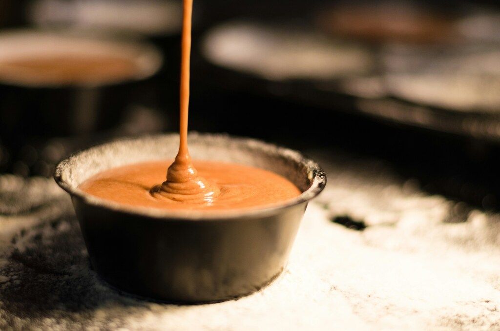 Masa de pastel de chocolate vertiéndose en un molde para hornear