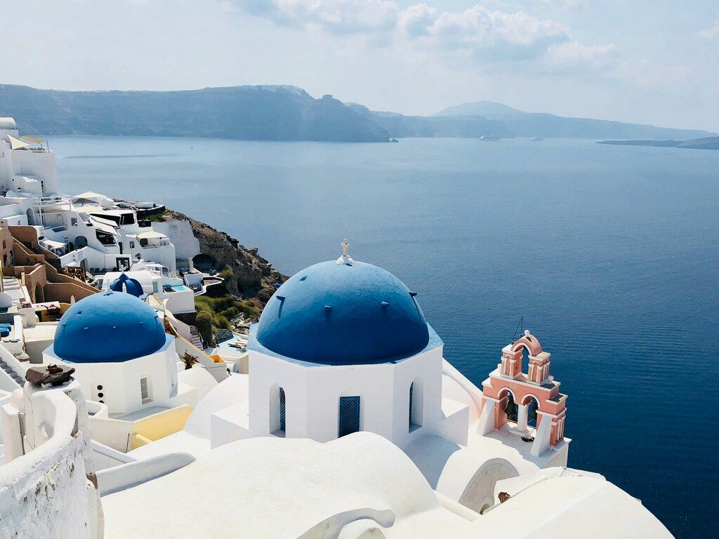 Vue emblématique de Santorin avec ses dômes bleus et la mer Égée en arrière-plan.